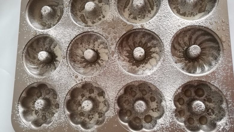 肉松蓝莓甜甜圈,10.撒上低筋粉,然后倒扣过来,倒掉多余的粉