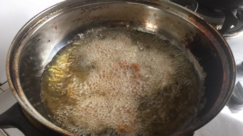 炸五香肉,油热后,把肉片伸展平,一片一片放入油锅。开始大火,然后转入中小火,并且间隔翻面。
