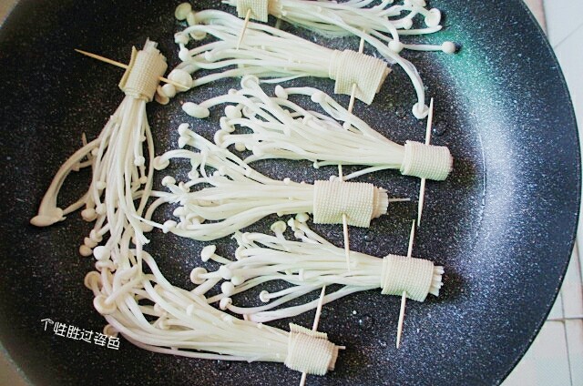 豆皮卷金针菇,把卷好的金针菇放入锅内