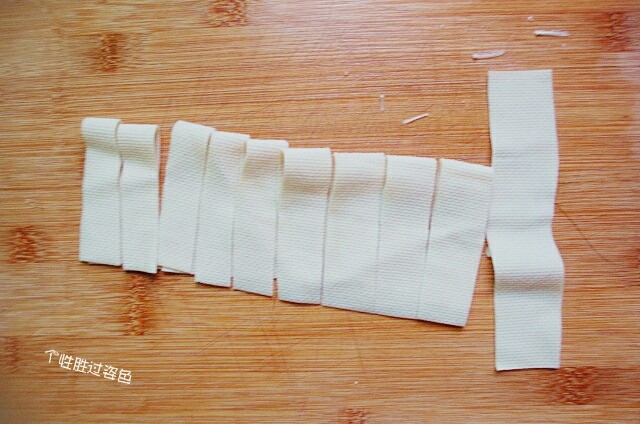 豆皮卷金针菇,豆腐皮用刀切成长条