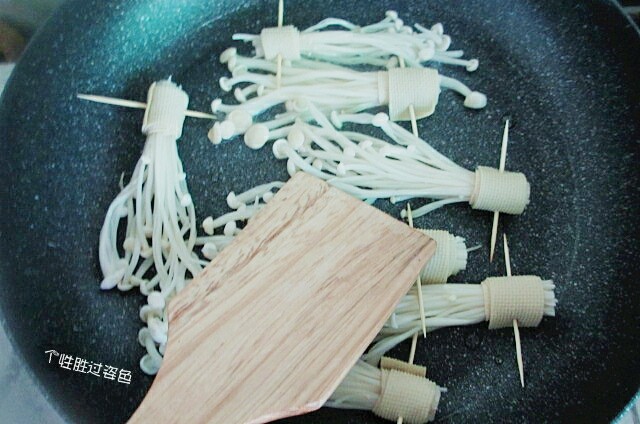 豆皮卷金针菇,用饭铲按压一下，熟的更快