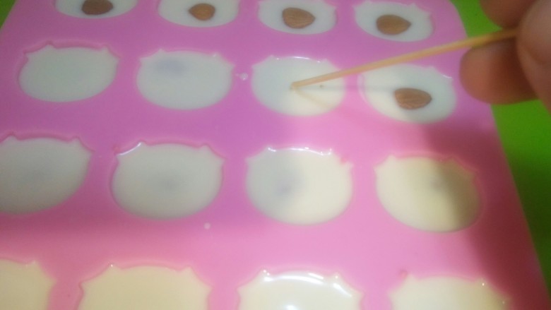 dly猪猪造型巧克力,用牙签轻轻的,轻轻的,轻轻的点果仁,巧克力给它盖住才好看。注:这是适合新手的做法,这样巧克力不用调温,避免了掌握不好温度而做失败的新手哦。大师绕行。