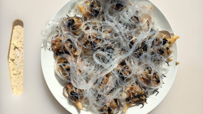 豆豉蒜蓉酱蒸蚬子,喜欢吃粉丝的把粉丝铺在上面就可以了(我试过把粉丝用蒜蓉酱炒一下再放在上面,不是很好看,也会影响蚬子的味道)再在上面洒上些料酒。