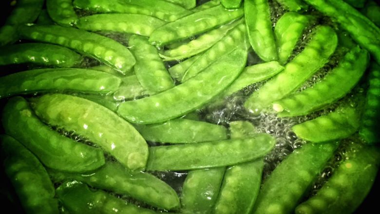 荷兰豆炒腊肠,锅内烧水,荷兰豆洗净后放入水中煮熟。