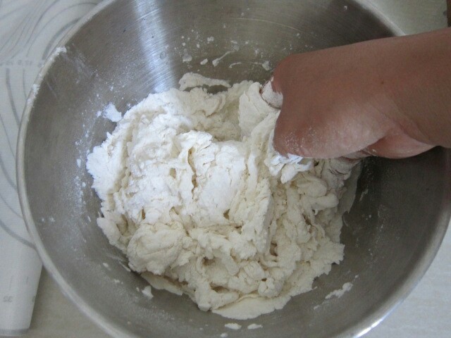 玉米猪肉水饺,将清水倒入面粉中边倒边搅混合揉成稍硬点的面团醒20分钟(揉成比包子稍硬点的面团)