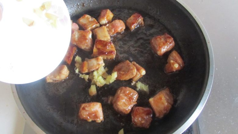 排骨红薯米饭,煸炒排骨上色后加入姜末煸炒;