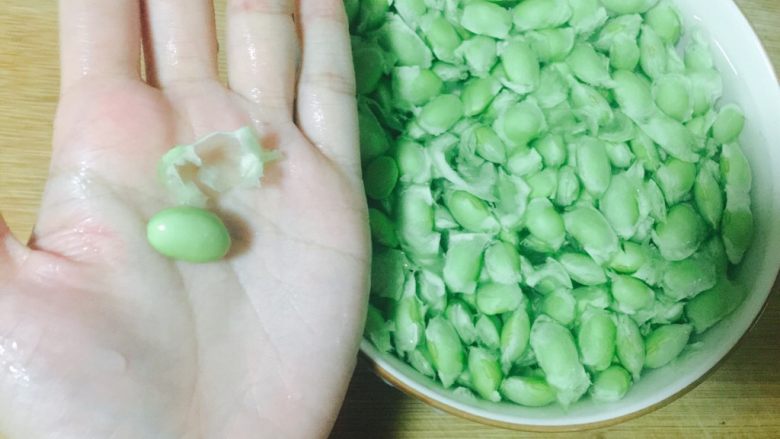雪菜毛豆炒肉沫,把毛豆泡水里搓洗,搓掉外面包裹的这层膜