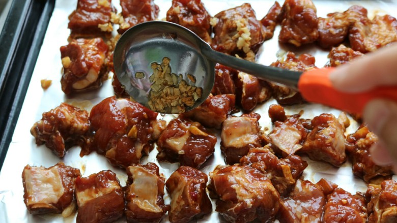 ≈蒜香烤排骨≈烤箱版,把腌制好的排骨取出,摆入烤盘,淋上蒜油,这时把烤箱预热到230度