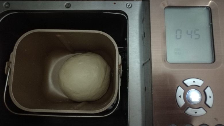 果干鸡肉披萨,面团内所有材料按照先液体后固体放入面包机,酵母挖坑放在最上面。启动面包机和面程序15分钟,揉成光滑的面团。