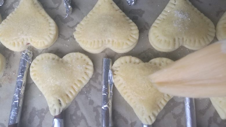 爱心夹心挞饼,最后在表面刷上剩余的蛋液,撒上白砂糖。