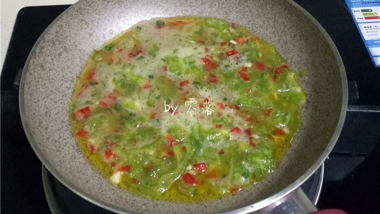 苦瓜蛋脯,倒入苦瓜蛋液,借助铲子将食材铺均匀;