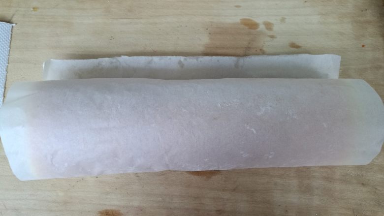 草莓蛋糕卷,借助油纸顺势卷起,定型。
