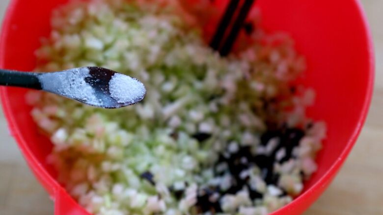 抱蛋煎饺,4.将芹菜和木耳碎放在盆里加一丁点盐拌匀。