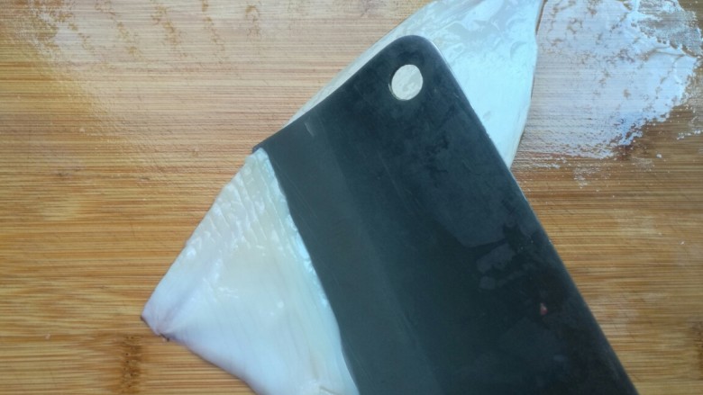 双椒爆鱿鱼,从鱿鱼的一侧斜45度角切下刀,一定记住是切里面,不是背部!深度3/4,不切断。