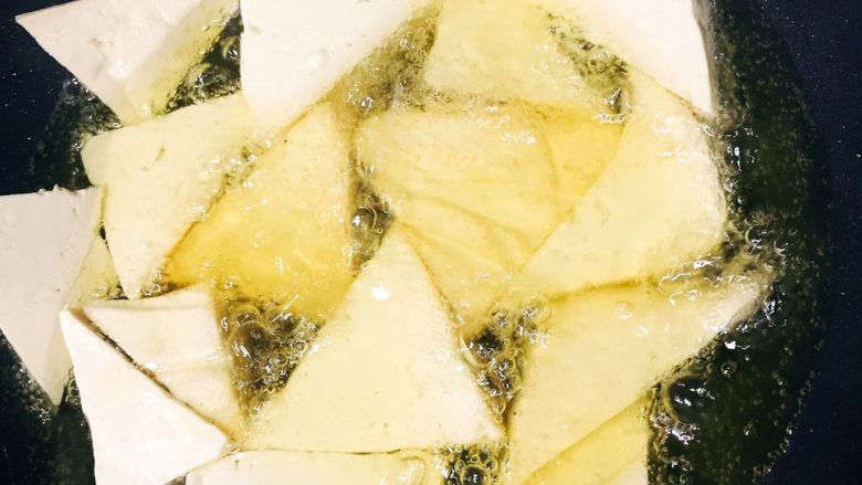 蜜汁豆腐,起锅倒入足量油，烧热后放入豆腐角，中火炸豆腐块直至两面金黄，有一层硬壳出现