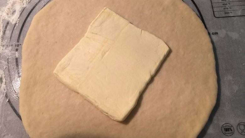 起酥手撕包,把发酵好的面团用手压出气体，放在室温静置松弛30分钟。在面团松弛的时候，可以准备裹入用的黄油了：把70克黄油切成片，提前平铺在保鲜袋里，用擀面杖擀开成正方形