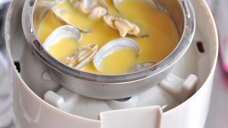 蟹味菇蒸鸡柳套餐,时间结束会发出提示音,将顶盖打开,要小心蒸汽烫着手,将顶层的菜取出,再把蛋液放入。