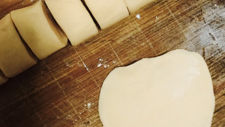 婴儿牛肉饺子,将长条面粉切成小节，然后将每节面粉捏成薄皮。