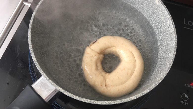 高纤低脂的全麦蔓越莓贝果,4)煮糖水
糖水沸腾后转小火煮贝果。正反各30秒。
发酵完成的贝果,是可以浮在水面上的,如果下沉,捞出后擦干水分继续发酵。