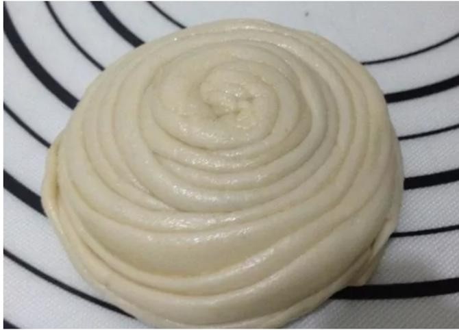 手抓饼,饼皮折叠成长长的一条,从一头边抻边卷,盘成一团,松弛20分钟。