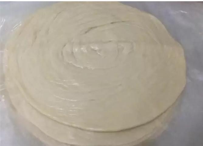 手抓饼,将松弛好的面团擀成薄饼,手抓饼坯子就完成啦!一次可以多做几个,每一个饼坯用油纸或保鲜膜隔开,放在冰箱冷冻柜里,每次吃的时候不用解冻,直接放在锅中烙就可以了。