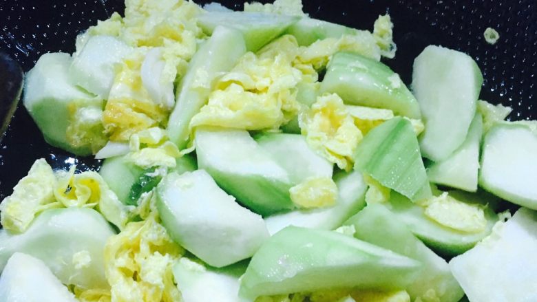 丝瓜炒蛋,加入丝瓜和蒜翻炒，再加水焖煮几分钟