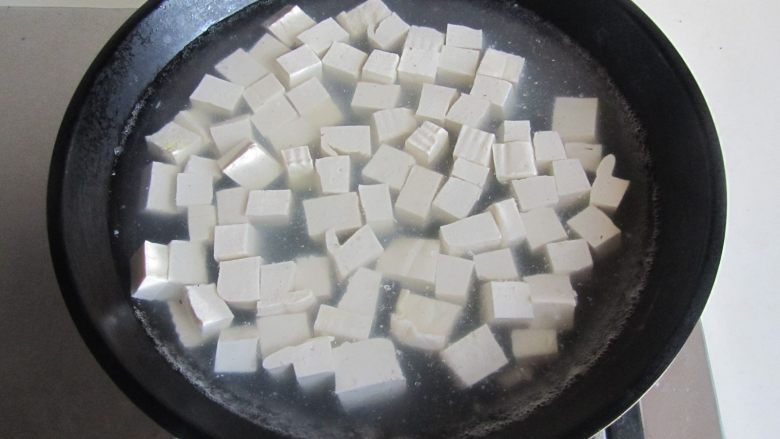 毛豆米双色豆腐,再将豆腐块放入里面焯煮一分钟捞出;