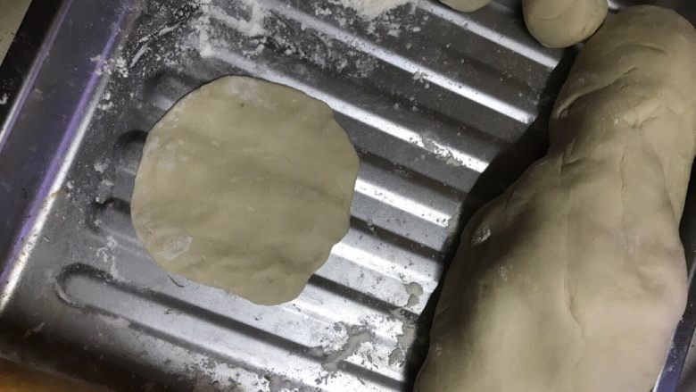 榨菜肉包,把发酵好的面粉搓成长条,在切断,大小看图,用擀面杖压平。如图这样,在将馅料放入包子皮中间,开始扭折,一个包子就可以了。具体怎么包自己去摸索。我也是初学,自己摸索的几次,慢慢的就会知道了。