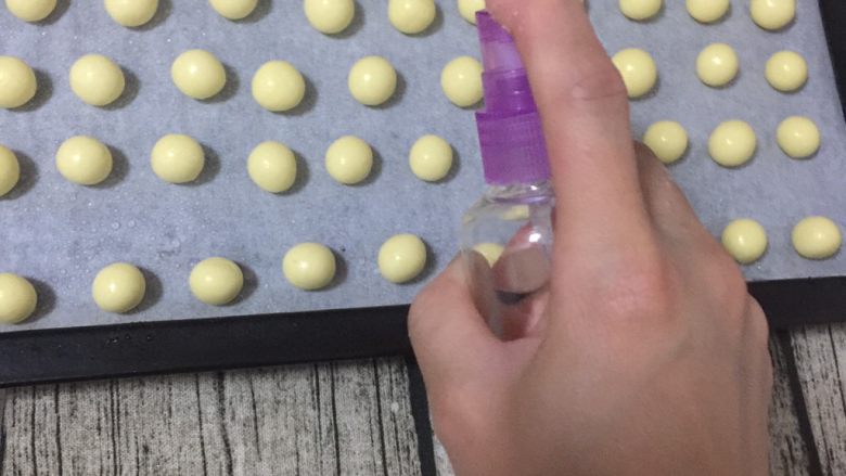 旺仔小馒头,圆球表面喷一层水,放入烤箱中层