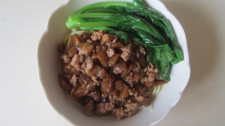香菇肉末面,加入制作好的香菇肉末馅, 再将焯烫好的菜芯摆放在碗中;