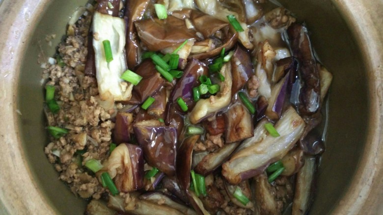 鱼香茄子煲,翻炒好后放入砂锅中,加入茄子,撒上葱粒和倒入少许水,加盖煮开