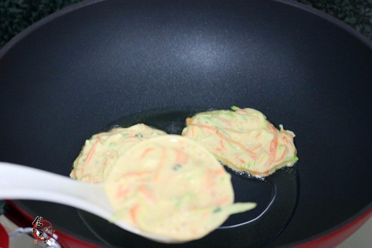 西葫芦鸡蛋煎饼,用勺子舀起面糊,放入煎锅中