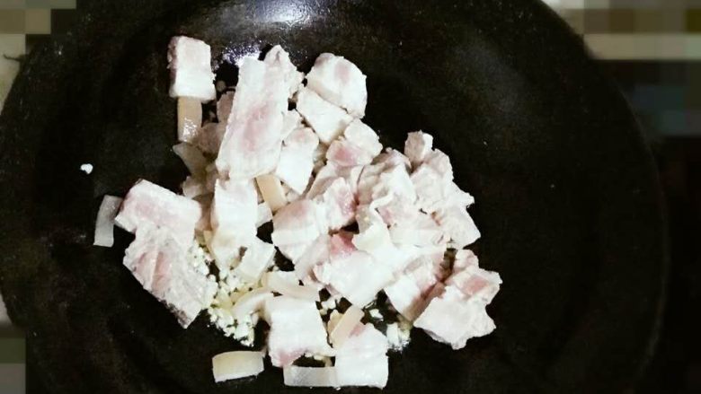 肉夹馍(家庭版),放入五花肉炒2分钟,再放入准备好的蒜末和姜末继续翻炒至五花肉两面金黄。