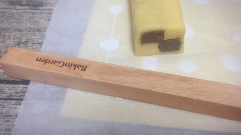 双色格子/棋盘饼干,步骤11切去的边料面团颜色分开,擀成薄片,刷上蛋液,把冻好的格子条包裹起来。包好后,切去多余的面片,盖上保鲜膜,冰箱冷冻20分钟,定型