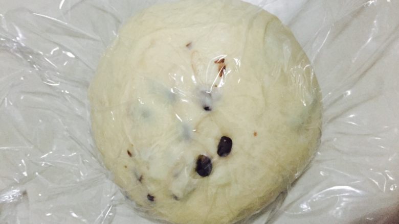 红豆淡奶油吐司#UKOEO801厨师机#,揉成一个光滑的面团,放在温室盖上保鲜膜进行第一次发酵
