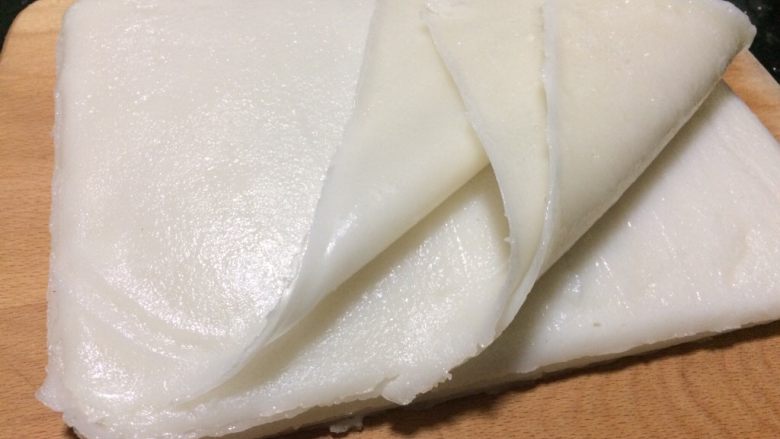 自制河粉,把所有做好的河粉全部按一个面依次叠加一起,光滑的一面朝底。
