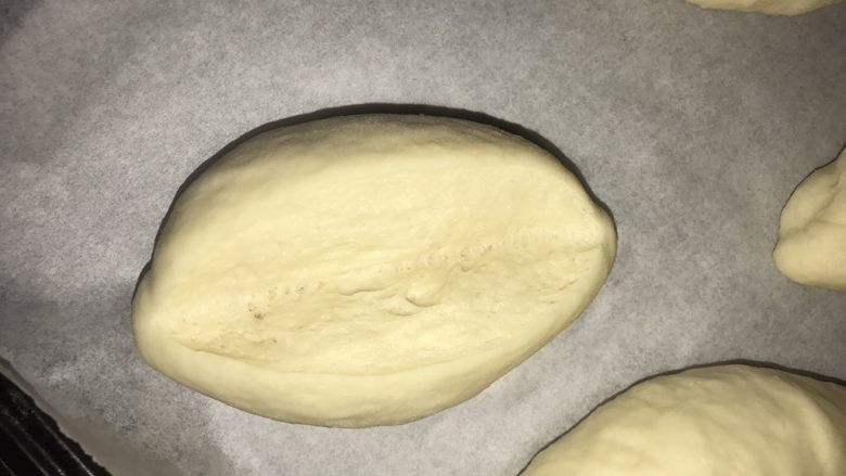 免出膜香肠包,整形成橄榄形,再次发酵至1倍大,纵向中间割开