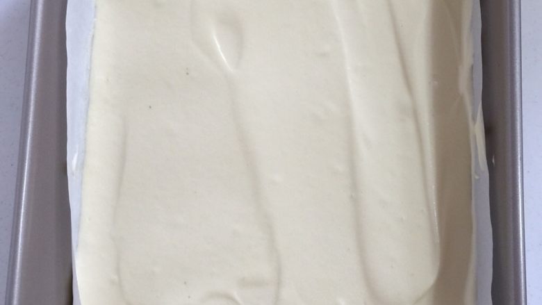 fluff棉花糖之草莓蛋糕卷,把蛋糊倒进烤好的图案上,用刮刀把表面刮平,轻轻地把烤盘震几下,震出里面的气泡!