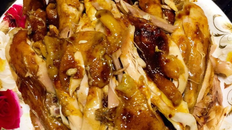 电饭锅盐焗鸡,把锅底的料汁淋上一点在撕好的鸡块上(也可以装在小碗中蘸着吃)
