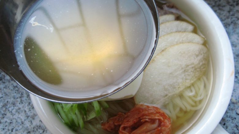 鲜族冷面:冰凉爽口.夏之美味,倒入冰镇好的冷面汤,再撒上香菜末和辣椒油,一碗味道纯正的韩式牛肉汤冷面就做好了。
