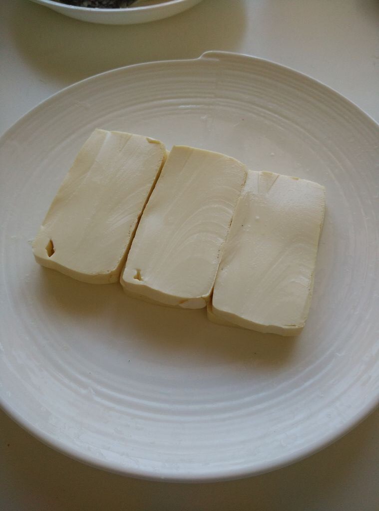 蟹味鳕鱼豆腐,在盘子里,把豆腐切片垫底。