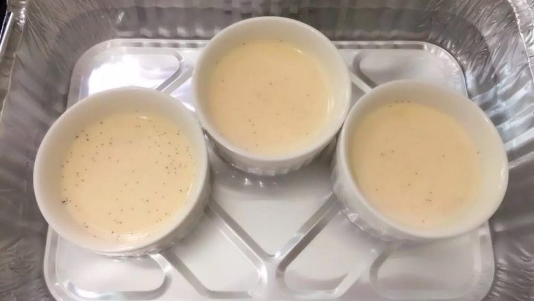 法式焦糖布丁Crème brûlée,準備2-3個布丁碗 輕輕倒入蛋液 如果表面有氣泡用湯匙將氣泡撇去 深底烤盤內注入熱水 熱水高度至布丁碗1/3或一半