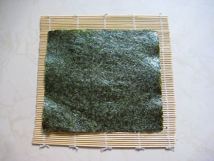 牛油果紫菜包饭:适合夏季的高营养清爽主食,9. <a style='color:red;display:inline-block;' href='/shicai/ 75428'>寿司海苔</a>铺在寿司帘上。