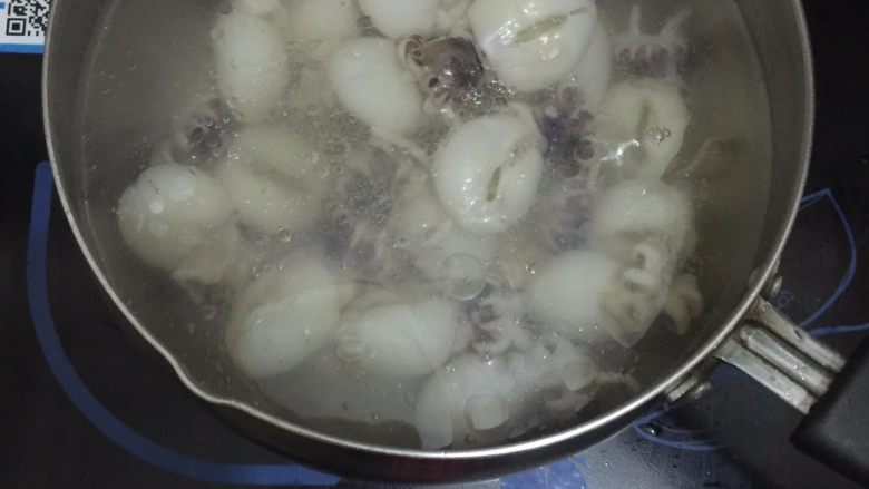 墨鱼仔烧土豆, 把奶锅里炸土豆的油盛出,再在奶锅里注入清水烧开,把墨鱼仔放入烧开的水中再次烧开即可把墨鱼仔捞出,过冷河(既是用冷水再冲洗一下)备用