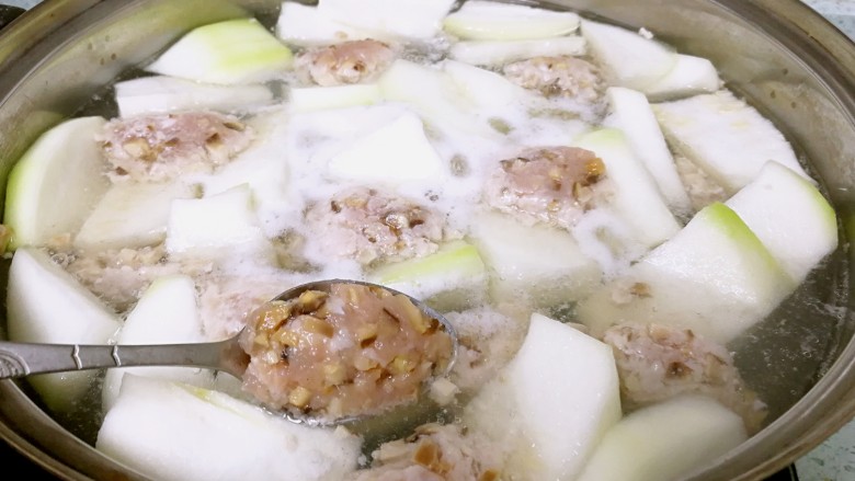 香菇肉滑蒲瓜汤,收小火。用勺子舀起肉泥,在碗边压一下,整一整形,再滑入汤中。