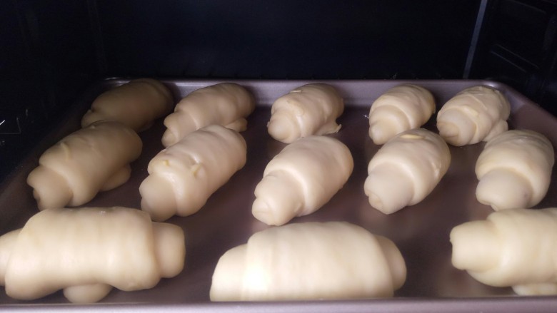 红薯奶香面包,放入烤箱二发温度设置35度，下面放一碗热水保存湿度，发好喷一点水，撒点白芝麻