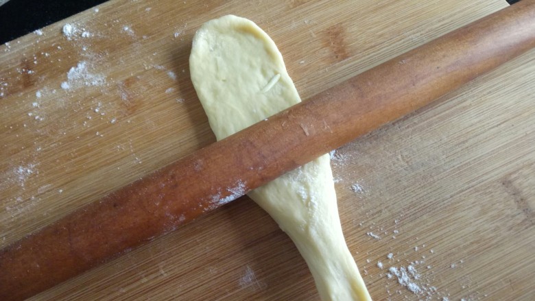 红薯奶香面包,下面一个手提起，擀面杖往下擀，擀成牛舌状。