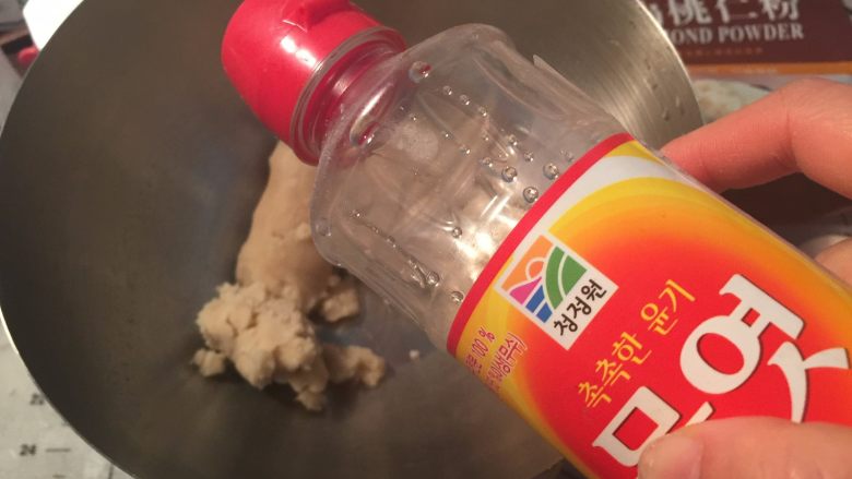 豆沙玫瑰曲奇,盆里放人白豆沙,加入水饴、清水用刮刀搅拌均匀
