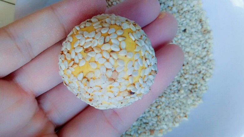 黄金南瓜球,裹上芝麻也要在搓圆,巩固芝麻,不易掉落,在炸时没有多余芝麻散落哦!