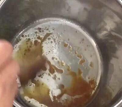 红烧排骨,炒糖：中火（明火炉中小火），倒入油和白糖，一定要不断翻炒，直至糖色变金黄色，如图
